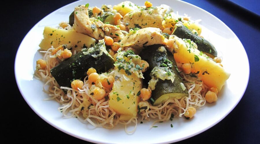 A plate of traditional Algerian rechta served with noodles, zucchini and potatoes.