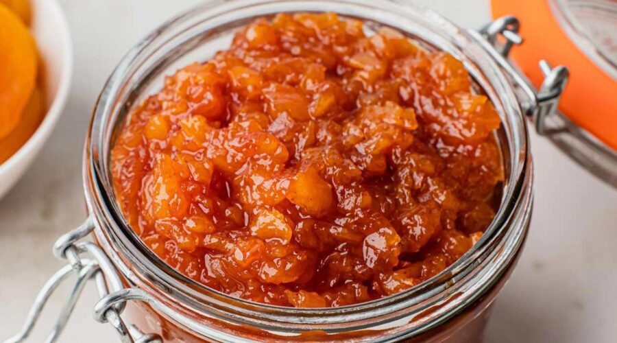 Apricot blatjang in a glass storage container.