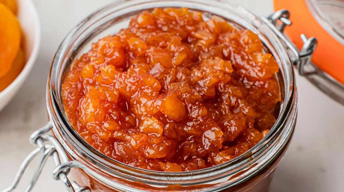Apricot blatjang in a glass storage container.