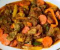 Cameroon Poulet DG - A dish containing spiced chicken, ripe plantains, and vegetables served on a plate.