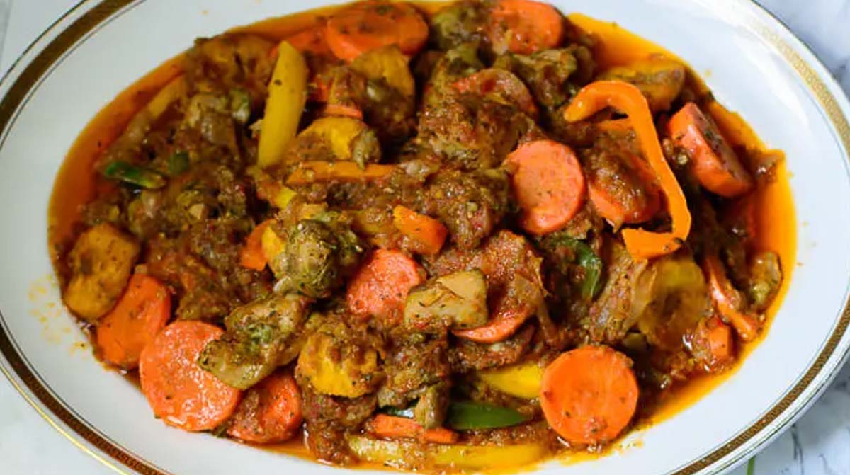 Cameroon Poulet DG - A dish containing spiced chicken, ripe plantains, and vegetables served on a plate.