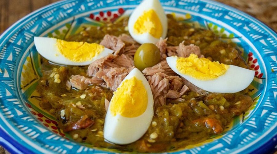 Plate of Mechouia salad with boiled eggs and an olive in the middle