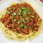 Somalian baasto served on a plate with a ripe peeled banana