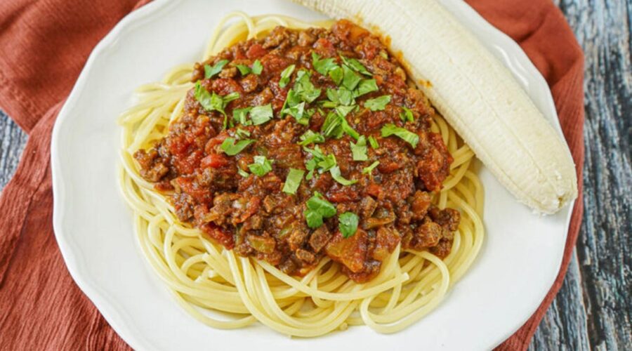 Somalian baasto served on a plate with a ripe peeled banana