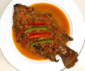 Kenyan style whole fried tilapia stew served on a plate