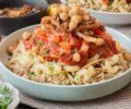 Egyptian Koshari with rice, lentils, pasta, chickpeas, spiced tomato sauce, and crisp onions