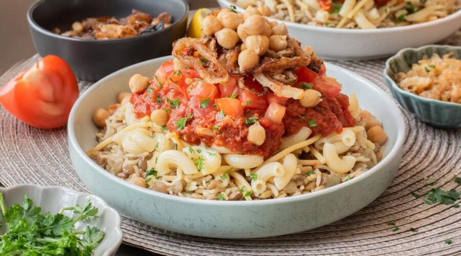 Egyptian Koshari with rice, lentils, pasta, chickpeas, spiced tomato sauce, and crisp onions
