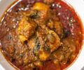 Liberian palm butter soup with chicken, smoked fish and chile in a rich palm-nut broth