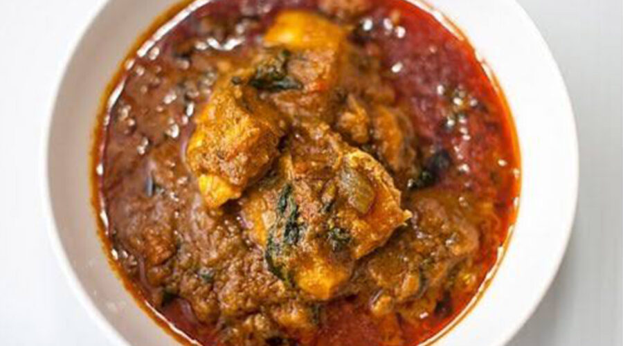 Liberian palm butter soup with chicken, smoked fish and chile in a rich palm-nut broth