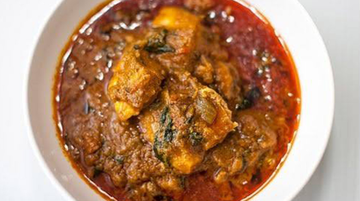 Liberian palm butter soup with chicken, smoked fish and chile in a rich palm-nut broth