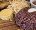 Ghanaian waakye rice and beans served with a boiled egg, gari and accompaniments