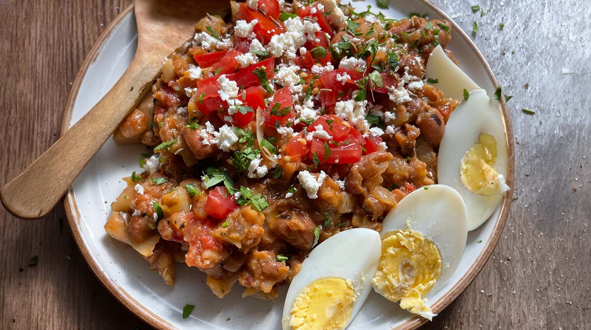 Ful medames with tender fava beans, fresh herbs and an oil drizzle