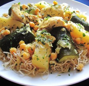 A plate of traditional Algerian rechta served with noodles, zucchini and potatoes.