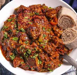 A plate of Ethiopian awaze tibs with a side of injera.