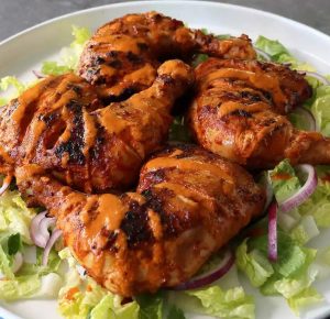 Peri Peri chicken thighs served with lettuce in a pan